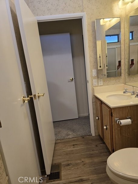 12618 3rd Street, Unit 63 Yucaipa, CA 92399 - Photo 36 of 65 a bathroom with a sink a toilet a mirror and vanity