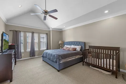 a spacious bedroom with a bed and a ceiling fan