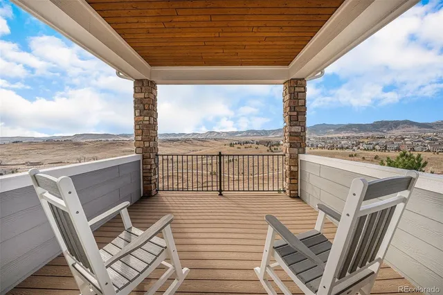 a view of a balcony with wooden floor and ocean view