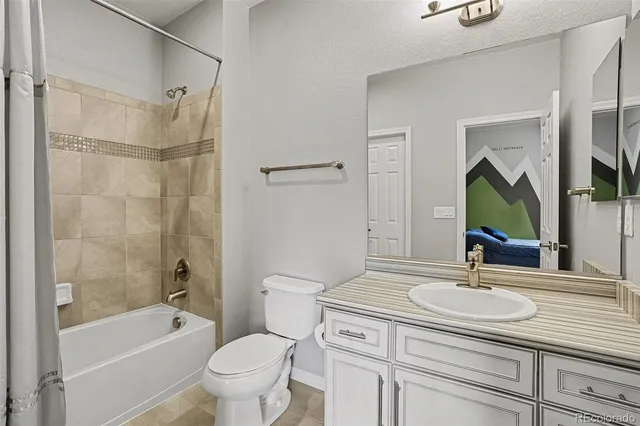 a bathroom with a granite countertop sink a toilet a mirror and shower