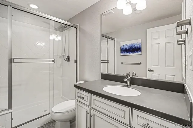a bathroom with a granite countertop sink toilet and shower