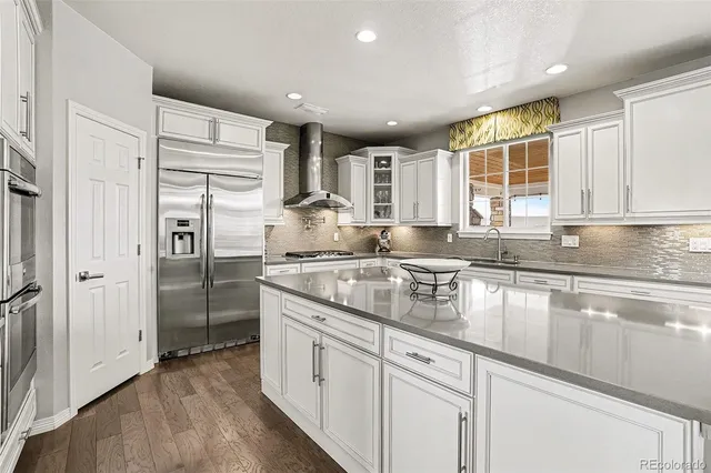 a kitchen with stainless steel appliances granite countertop a refrigerator and a sink