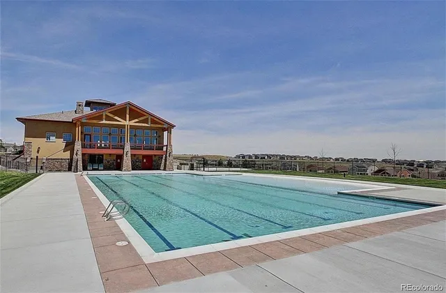 a view of a big house with a big yard and large trees