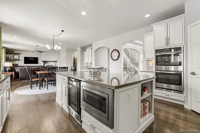 a kitchen with stainless steel appliances kitchen island granite countertop a stove and a sink