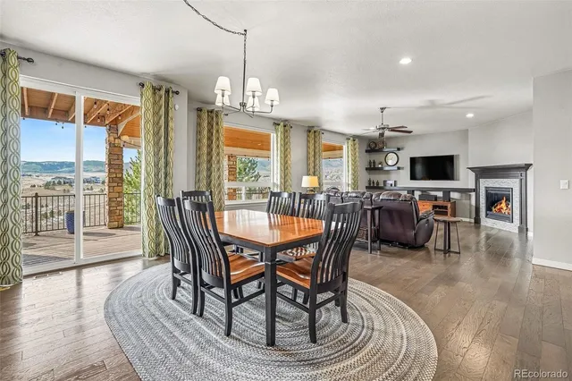a dining room with furniture a chandelier and wooden floor