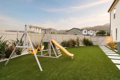 a view of a house with a yard and a slide