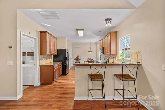 a kitchen with stainless steel appliances kitchen island granite countertop a refrigerator and microwave