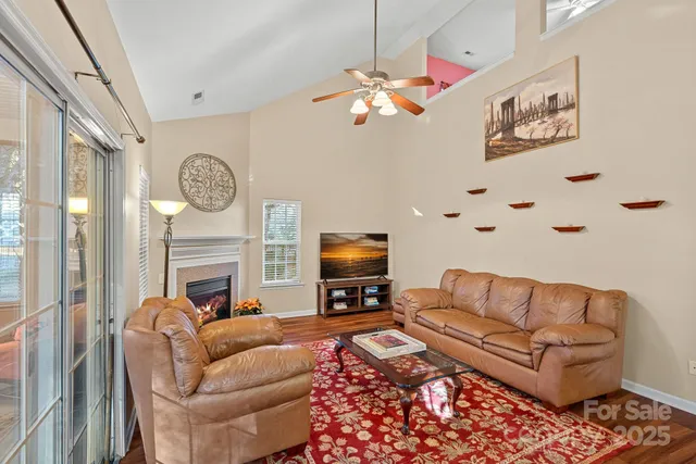 a living room with furniture a fireplace and a flat screen tv