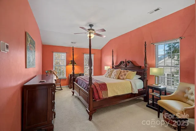 a spacious bedroom with a bed and a chandelier
