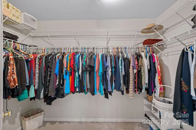 a view of walk in closet with clothes