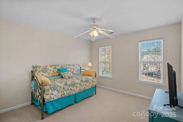 a bedroom with a bed tv and a window