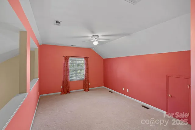 an empty room with a ceiling fan and window