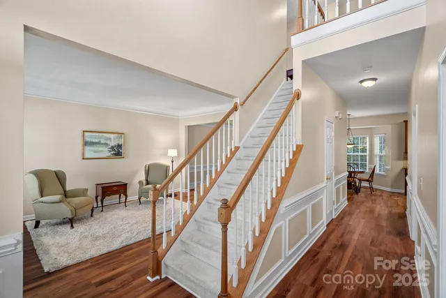a view of staircase and living room with wooden floor
