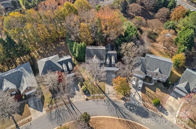 an aerial view of a house with a yard and trees