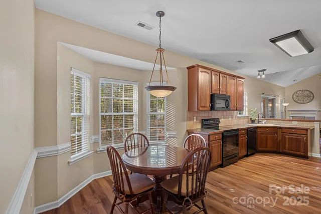 a kitchen with granite countertop a dining table chairs stove and granite counter tops