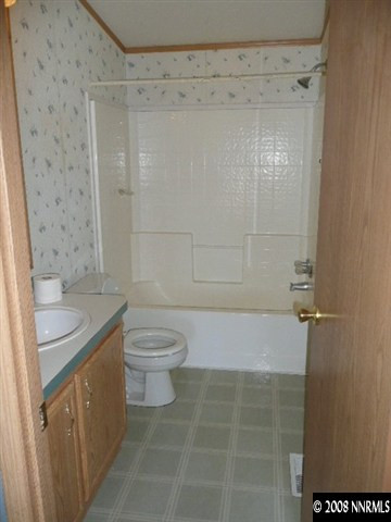 7067 Milburn Lane Fallon, NV 89406 - Photo 6 of 9 a bathroom with a granite countertop sink toilet and shower