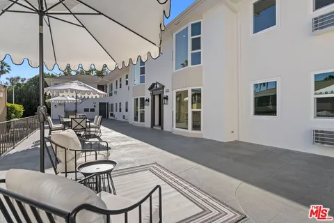 a view of a patio with table and chairs and potted plants