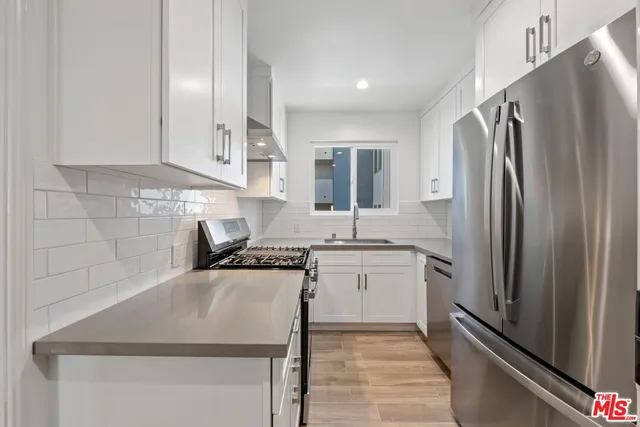 a kitchen with stainless steel appliances a refrigerator sink and stove