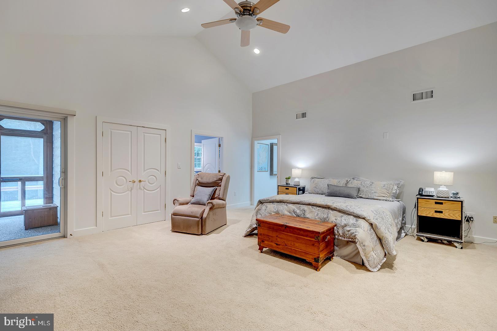 22095 Wilson Road Georgetown, DE 19947 - Photo 40 of 137 a spacious bedroom with a bed and a chandelier