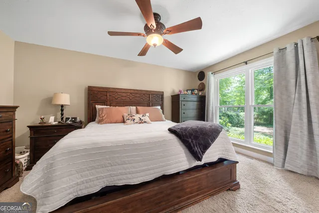a bedroom with a bed and a large window