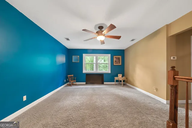 a view of a livingroom with a ceiling fan and window