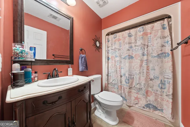 a bathroom with a sink a toilet and shower curtain