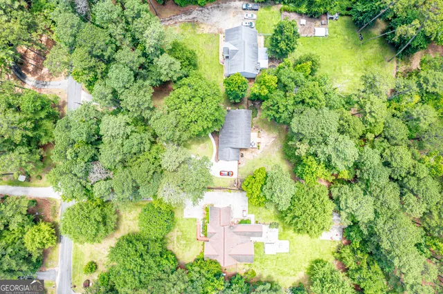 an aerial view of residential house with outdoor space and trees all around
