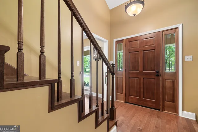 an entryway with wooden floor and stairs