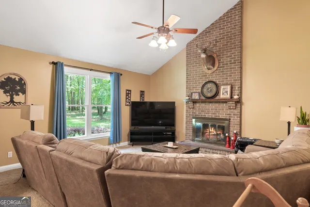 a living room with furniture a flat screen tv and a fireplace