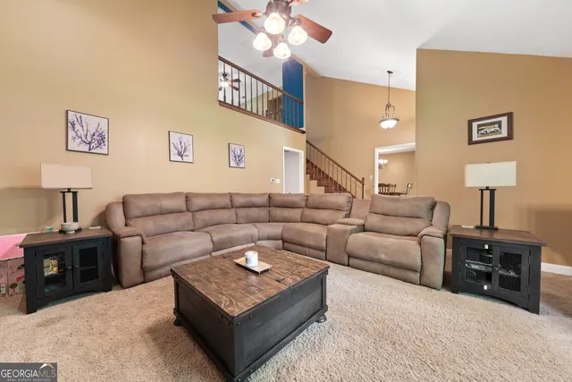 a living room with furniture a chandelier and a flat screen tv