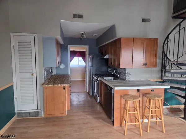 a kitchen with stainless steel appliances granite countertop a sink and a refrigerator