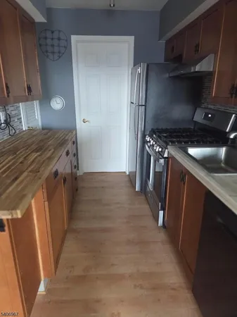 a kitchen with granite countertop a sink and stainless steel appliances