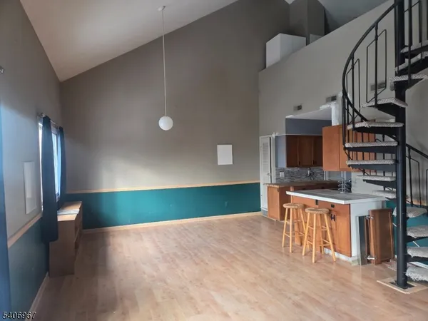 a kitchen with stainless steel appliances a sink cabinets and a wooden floor