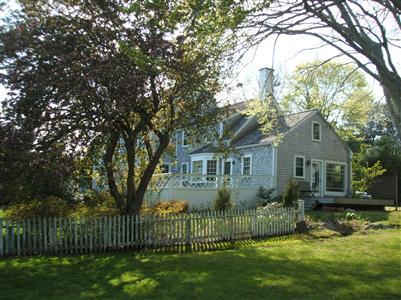 Undisclosed Address Falmouth, MA 02540 - Photo 2 of 13 a front view of a house with a garden and yard
