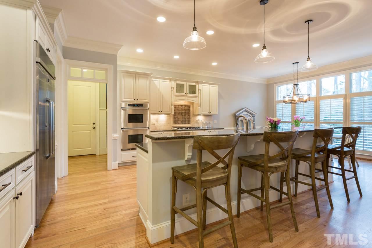 3215 Rain Forrest Way Raleigh, NC 27614 - Photo 4 of 30 Creamy white cabinets, stainless appliances, granite counters and under cabinet lighting.