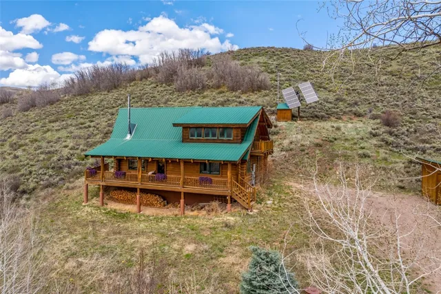 a view of a wooden chairs and a table in the patio