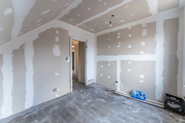 an empty room with mirror and entrance