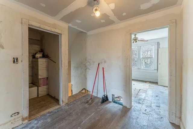 a view of a hallway with entryway and wooden floor