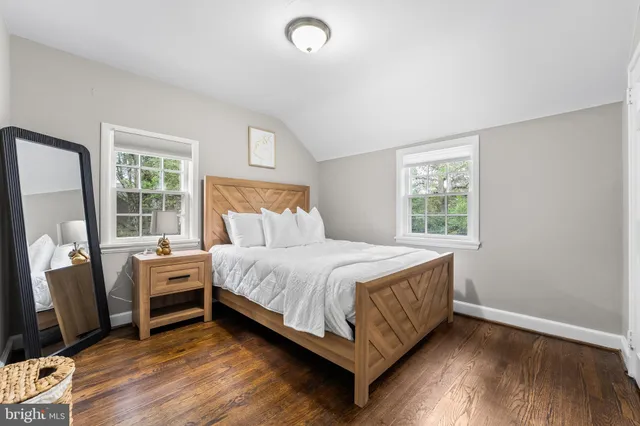 a bedroom with a bed and a flat tv screen on the dresser