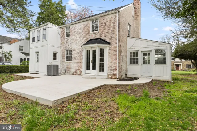 a view of a white house with a yard and large tree