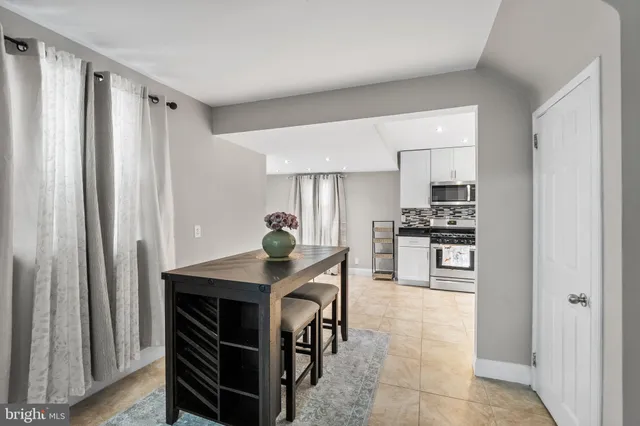 a kitchen with kitchen island a counter top space a sink stainless steel appliances and cabinets