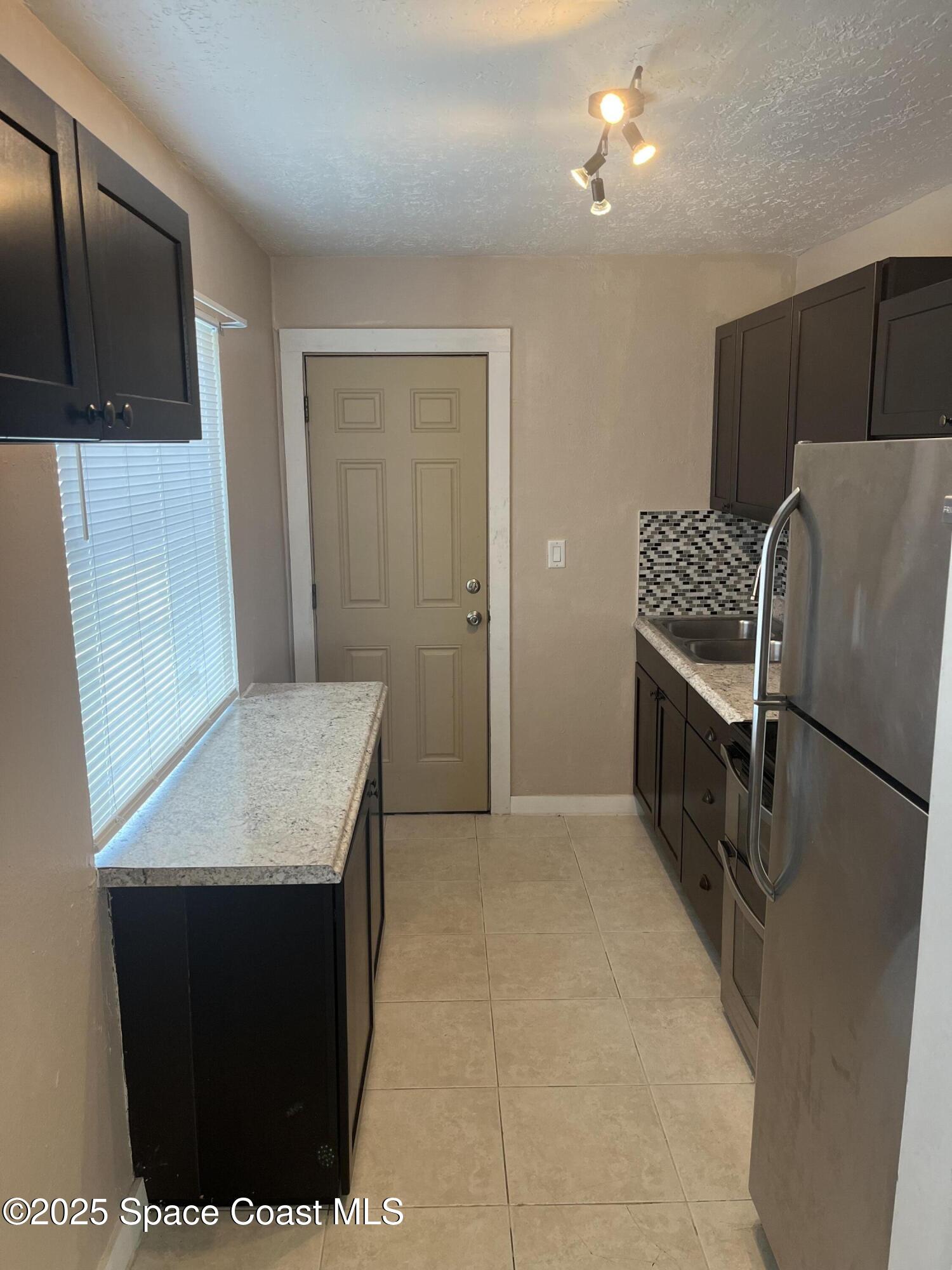510 East Strawbridge Avenue, Unit BSALON Melbourne, FL 32901 - Photo 4 of 11 a kitchen with stainless steel appliances a refrigerator and a stove