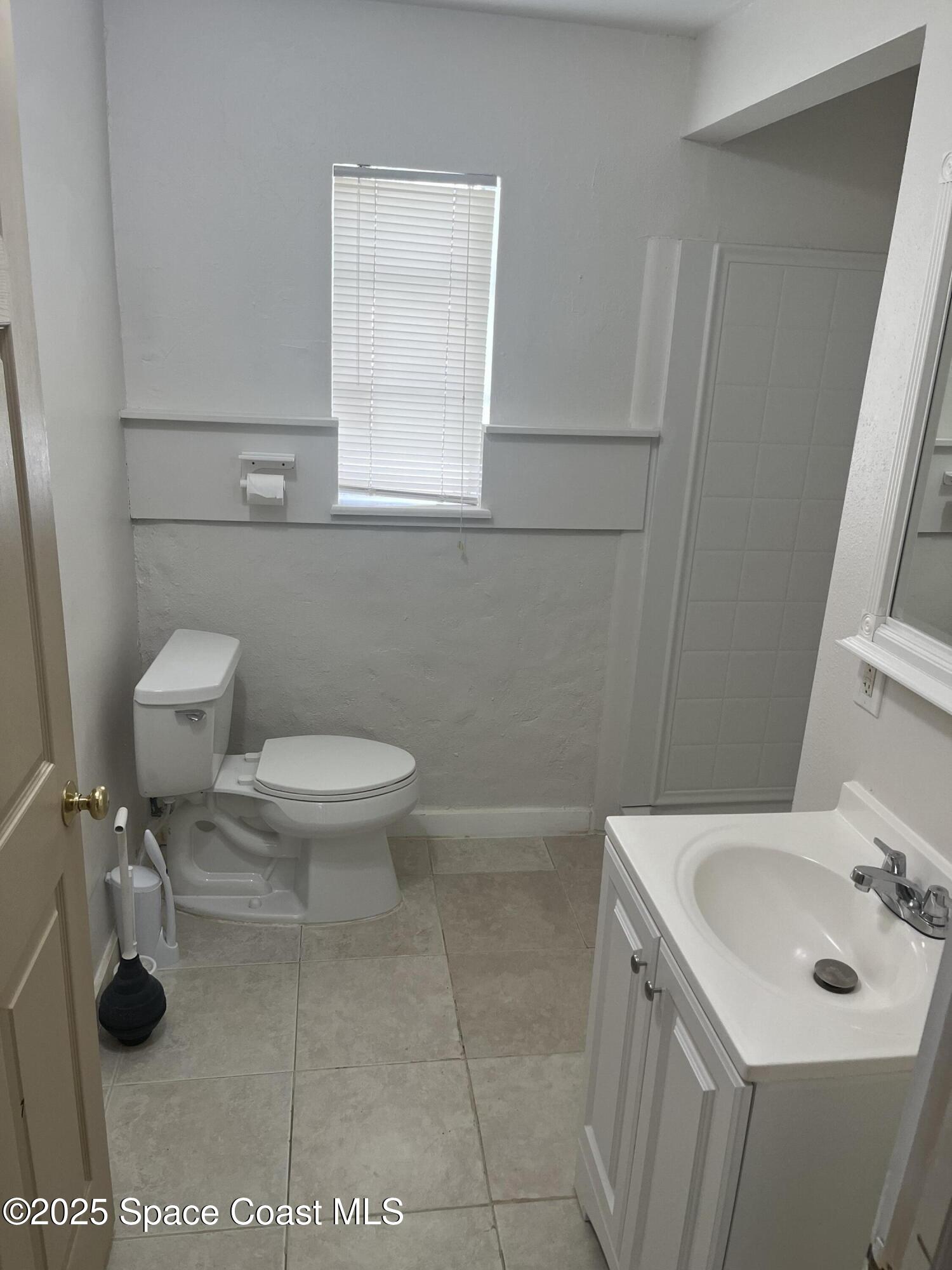510 East Strawbridge Avenue, Unit BSALON Melbourne, FL 32901 - Photo 9 of 11 a bathroom with a toilet sink and mirror