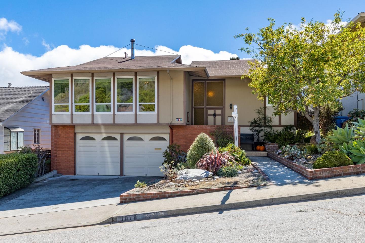 1079 Park Pacifica Avenue Pacifica, CA 94044 - Photo 2 of 43 a front view of a house with lots of potted plants