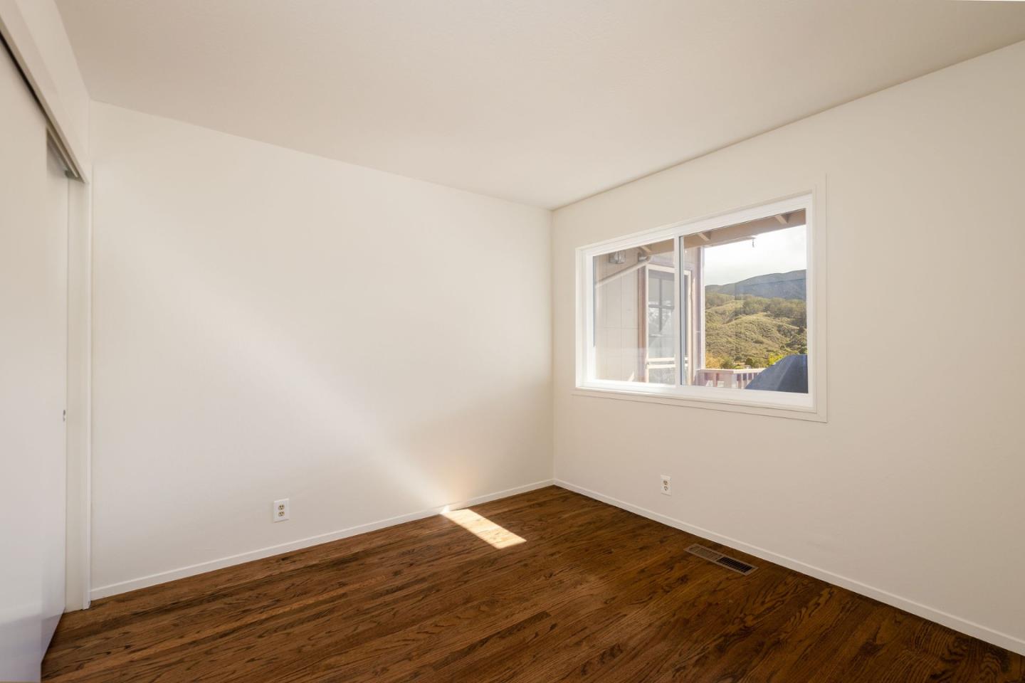 1079 Park Pacifica Avenue Pacifica, CA 94044 - Photo 21 of 43 an empty room with wooden floor and windows