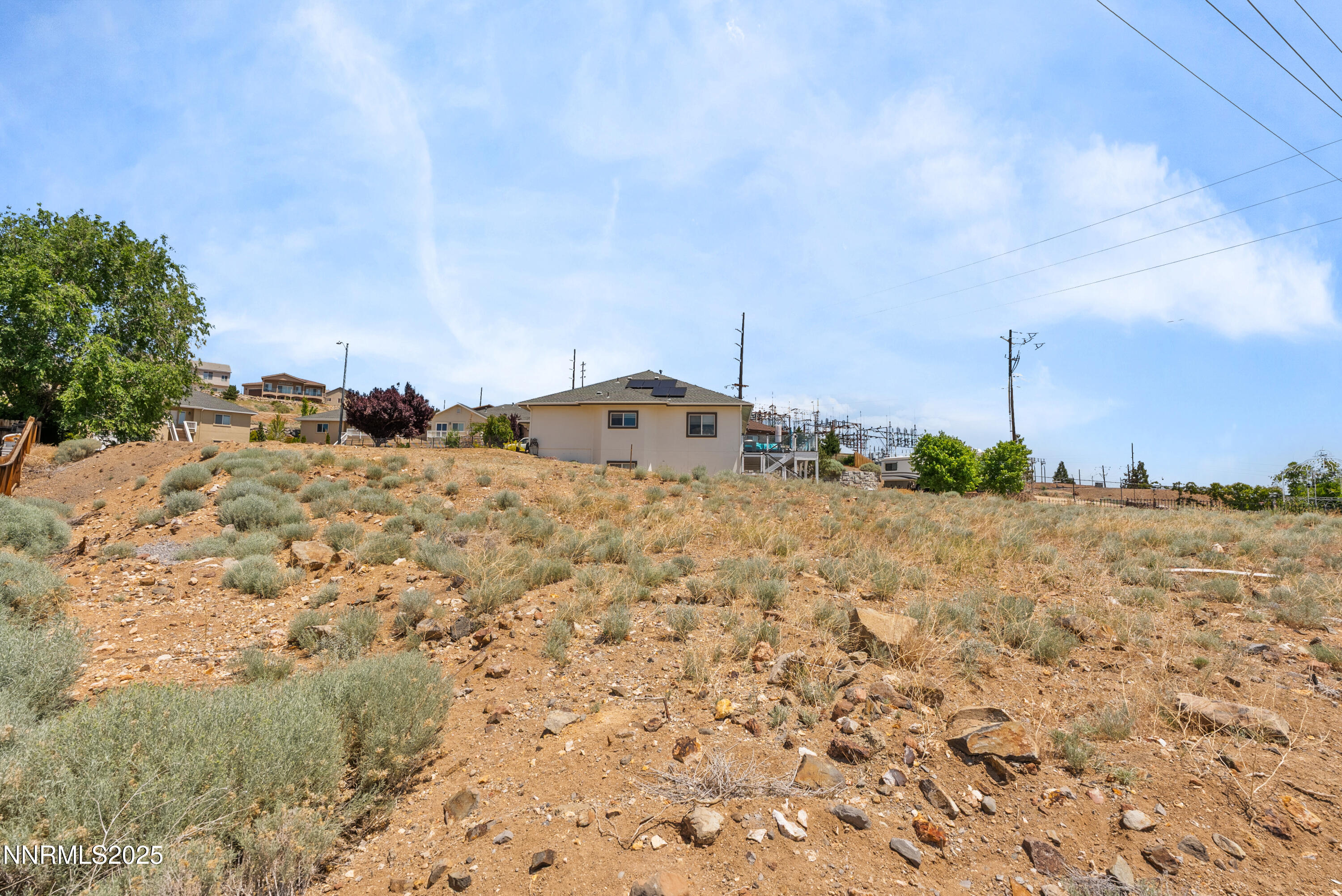 970 Demos Court Reno, NV 89512 - Photo 6 of 26 a view of a dry yard covered with snow in the background