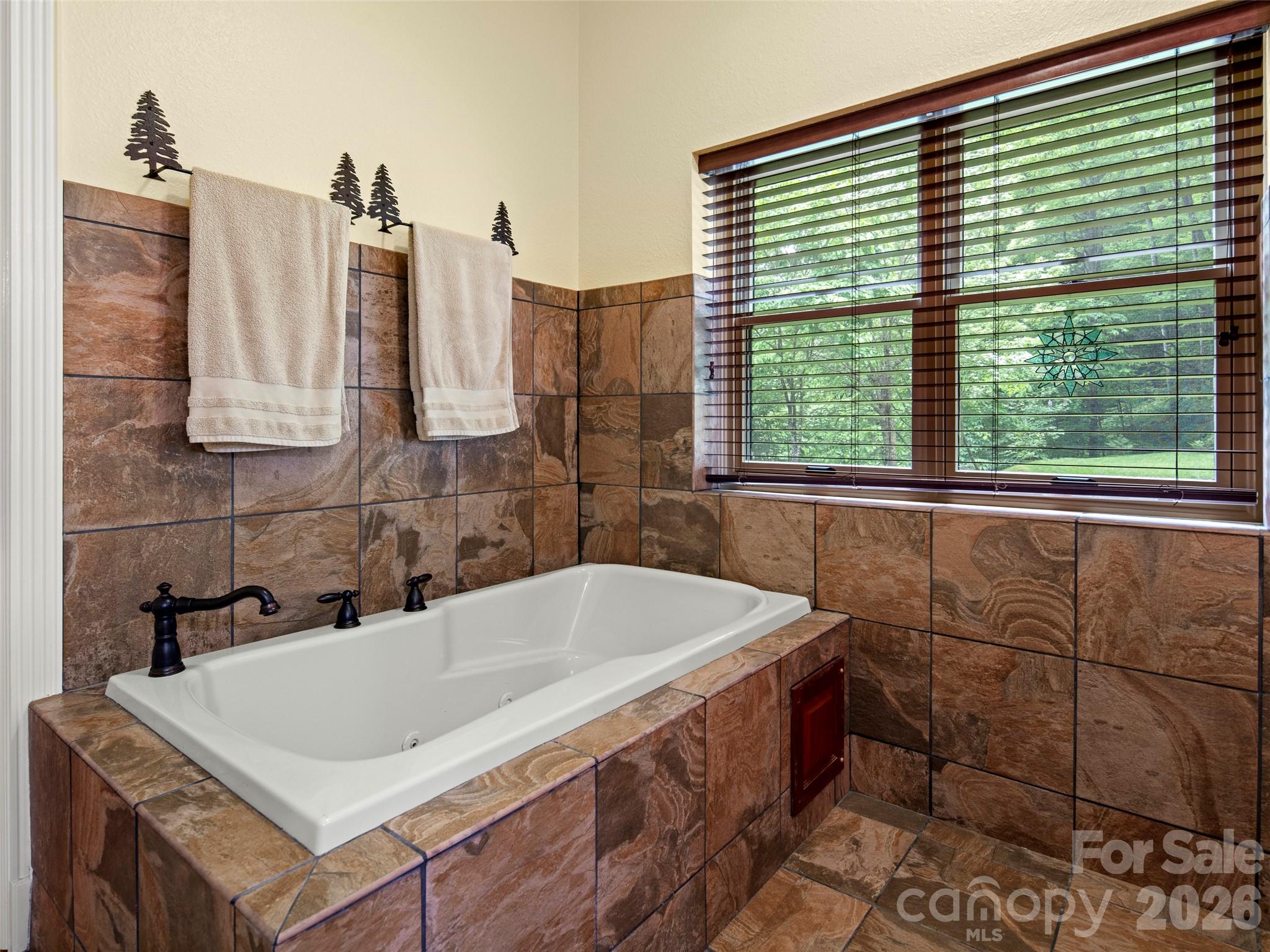 79 Ward Road Maggie Valley, NC 28751 - Photo 27 of 48 a bath tub sitting in a bathroom next to a window