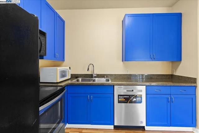 a kitchen with granite countertop wood cabinets stainless steel appliances and a sink