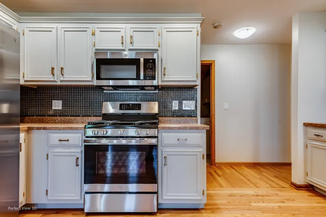 a kitchen with stainless steel appliances a stove and a microwave