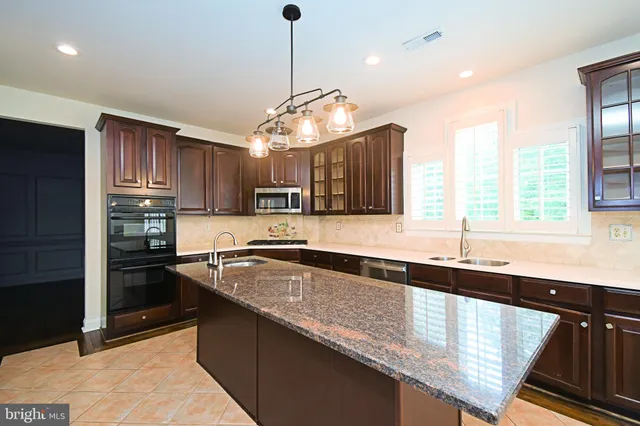 a large kitchen with kitchen island a sink appliances wooden floor and a counter top space